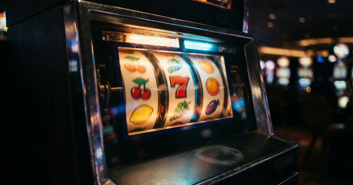 Svjetleći koluti automata za igru u tamnoj prostoriji, izbliza — besplatni casina u hrvatskoj